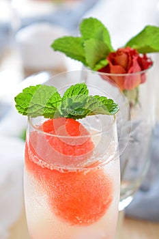 Sparkling cocktail with watermelon and melon ball-shaped pieces and ice