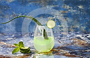 Sparkling cucumber mint gin and tonic fizz with aloe vera on marble table. Copy space. Dragon tail cocktail for fans party.