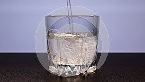 Sparkling mineral water is poured into a transparent glass