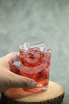 Sparkling red water soda with ice cubes. Summer iced drink