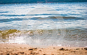 Sparkling silver waves in the sand. Summer beach background with a space for text