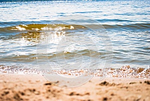 Sparkling silver waves in the sand. Summer beach background with a space for text