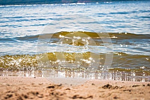 Sparkling silver waves in the sand. Summer beach background with a space for text.