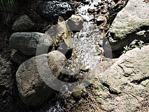 Sparkling water flowing on the stones,  in the summer   park,  in Kotka, Finland