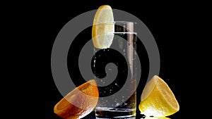 Sparkling Water With Lemon Wedge and Sliced Orange Rotate on Black Background