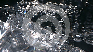Sparkling water a macro of bubbles floating with ice in a glass on black background