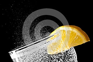 Sparkling water with an orange slice isolated on black background