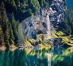 Sparkling waterfall on the Oeschinensee Lake. Splendid summer morning in the Swiss Alps, Kandersteg village location, Switzerland,