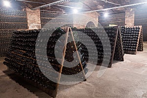 Sparkling wine bottles fermenting in winery cellar