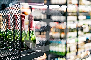 Sparkling wine on liquor store shelf. Champagne bottle on display in alcohol shop. Beverage section of supermarket.