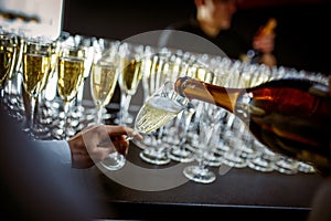 Sparkling wine is poured into a glass at a party