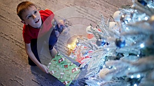 Sparks in the baby's eyes from opening presents under the magical Christmas tree