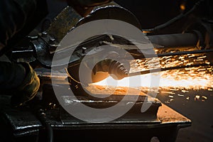 Sparks from circular saw at steel factory. Metal sawing close up.