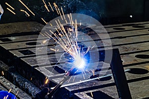 Sparks from electro gas welding at work in an electromechanical workshop