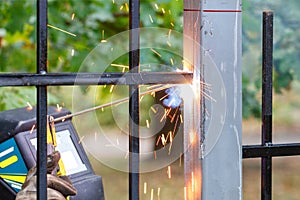 Sparks flame and arc of electric welding when welding a metal fence