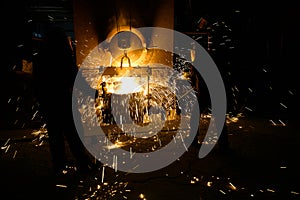 Sparks from melting steel, Men watching sparkling melting steel in furnace of foundry.