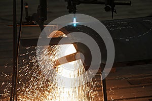 Sparks from a metal cutting machine in a factory.
