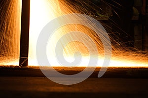 Sparks from a metal cutting machine in a factory.