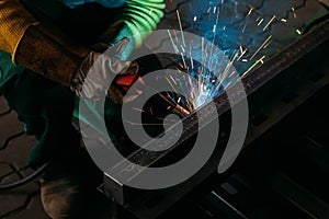 Sparks while welder uses torch to welding