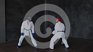 Sparring or single duels in taekwondo class. Pupils kicking in a fighting stance. Forceful attack and defense tactics