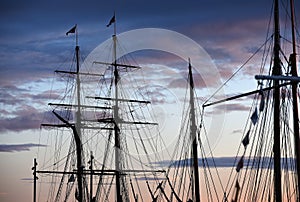 Spars of sailing ships against the background of the evening sky