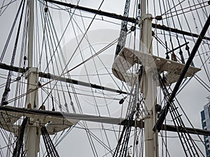 Spars and shrouds of a historical classic frigate ship holding rigging and rope for sailing