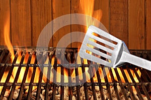 Spatula Close-up On The Hot Flaming BBQ Grill