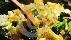 The spatula interferes with the mix of vegetables in the pan. Cooking Vegetarian Stew in a Frying Pan