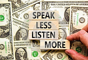 Speak less listen more symbol. Concept words Speak less listen more on wooden block. Beautiful background from dollar bills.