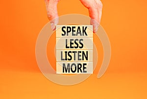 Speak less listen more symbol. Concept words Speak less listen more on wooden block. Beautiful orange table orange background.
