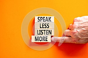 Speak less listen more symbol. Concept words Speak less listen more on wooden block. Beautiful orange table orange background.