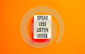 Speak less listen more symbol. Concept words Speak less listen more on wooden block. Beautiful orange table orange background.