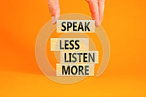 Speak less listen more symbol. Concept words Speak less listen more on wooden block. Beautiful orange table orange background.