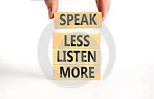 Speak less listen more symbol. Concept words Speak less listen more on wooden block. Beautiful white table white background.