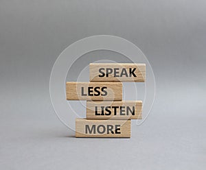 Speak less Listen more symbol. Wooden blocks with words Speak less Listen more. Beautiful grey background. Business and Speak less