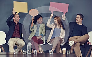 Speak your mind if you have business on it. a group of businesspeople holding up speech bubbles while waiting in line