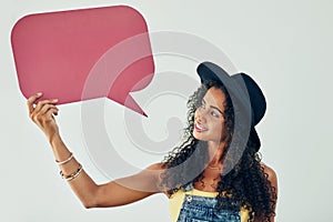 Speak your mind and let it be heard. Studio shot of an attractive young woman holding a speech bubble against a grey