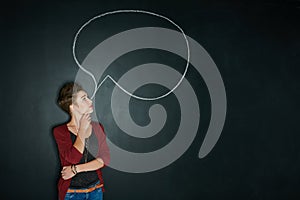 Speak your mind. Studio shot of a young woman posing with a chalk illustration of a speech bubble against a dark