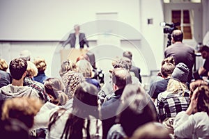 Business speaker giving a talk at business conference event.