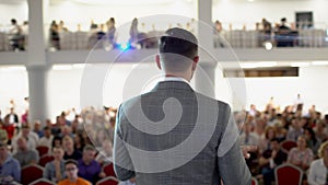 Speaker giving a talk on corporate Business Conference. Audience at the conference hall. Business event. A young man in