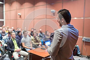 Public speaker giving talk at Business Event.