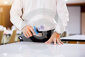 The speaker held the microphone in his hand with blurry conference room and projector