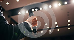 Speaker's Hand Holding A Microphone On Stage At A Conference Or Event