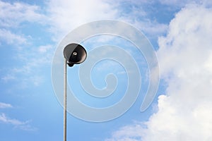 Speaker at top of the pole with sky background