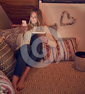 She speaks tech fluently. a young woman texting on her smartphone while relaxing in her bedroom at home.