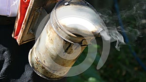 A special beekeeper smoker from which smoke comes out, for working in the hive and pumping out honey close up view