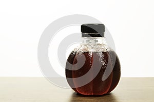 Special bottle shape of grape juice on wooden table with white background