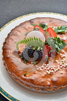 Special cake with blackberry and strawberry on white plate in re