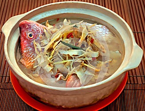 Special Clay Pot Tilapia Fish with Chinese Rice White Wine and Traditional Herb.