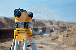 Special device level for surveyor builders, geodesy equipment close up in front of a ground work with people on blurred backgrou